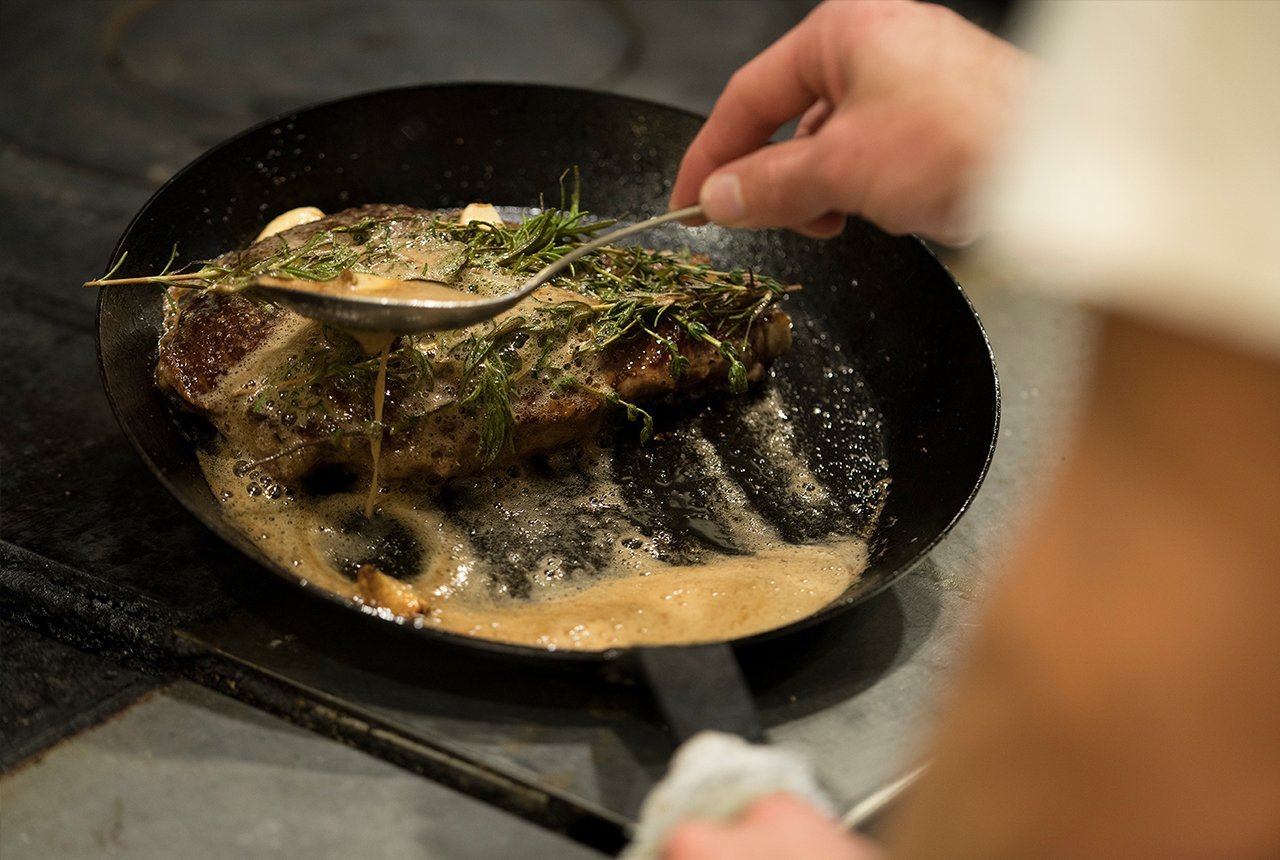 Chef Kevin Scharpf prepares a sirloin steak in a cast iron skillet